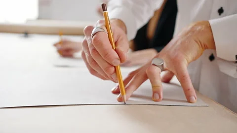Clothes making concept. Unrecognizable female tailor passing around pattern of Stock Footage 166361968
