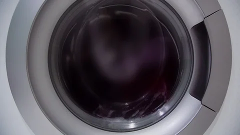 Clothes objects rotate in white washing machine closeup 動画素材 115398581