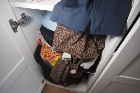 Clothes packed in a closet with some items showing 스톡 사진