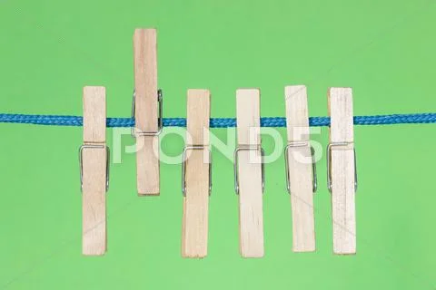 Clothes pegs on the green background Stock Photos