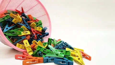 Clothes pins falling out of a basket on the white background, multi color  Video stock 306445709