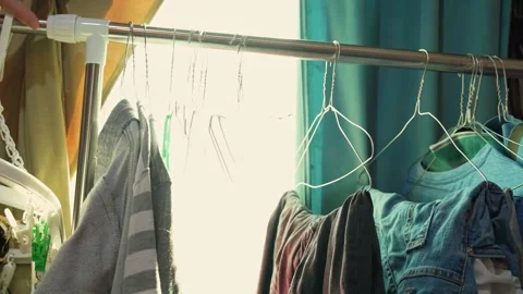 Clothes Rack with Open Curtains: Sunlit Home Laundry or Wardrobe Scene Stock Footage 313724507