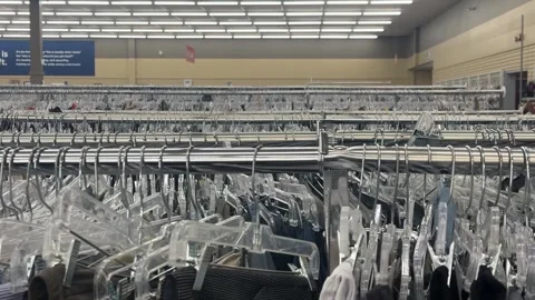 Clothes racks in a Thrift store displayed in rows pan Stock Footage 345966894