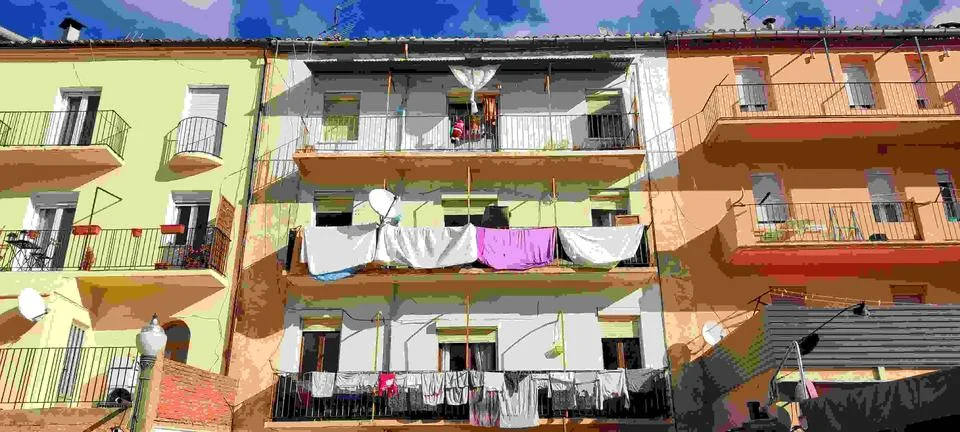 Clothes recently washed and put to dry on the balconies of the facades Stock Photos