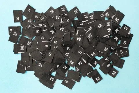 Clothes tags with different sizes. Top view. Flat lay. Clothing size S, M. Stock Photos