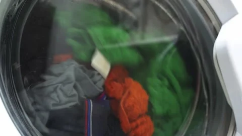 Clothes tumble and wash inside a modern washing machine Stock Footage 321796998