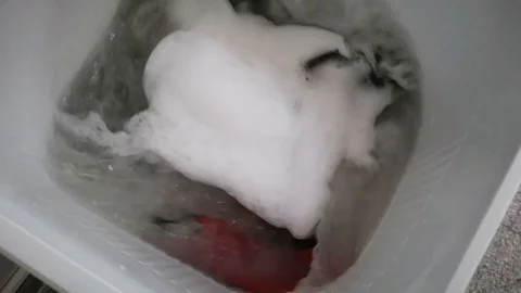Clothes in a washing machine with soap bubbles. washing machine is in operation. Stock Footage 113295319
