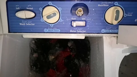 Clothes in a washing machine with soap bubbles. washing machine is in operation. Stock Footage 113295335