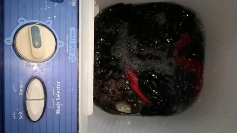 Clothes in a washing machine with soap bubbles. washing machine is in operation. Stock Footage 113295356