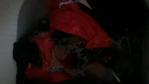 Clothes in a washing machine with soap bubbles. washing machine is in operation. Stock Footage 113295423