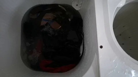 Clothes in a washing machine with soap bubbles. washing machine is in operation. Stock Footage 113295444