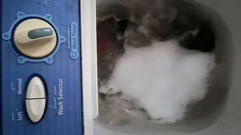 Clothes in a washing machine with soap bubbles. washing machine is in operation. Stock Footage 113295492