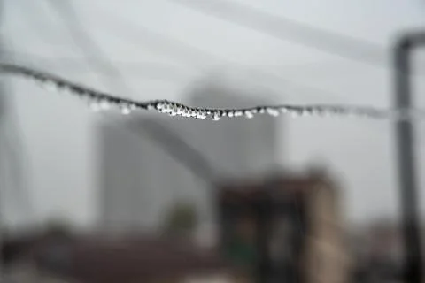 Clothesline cable full of small drops on a rainy day with a selective focus Stock Photos