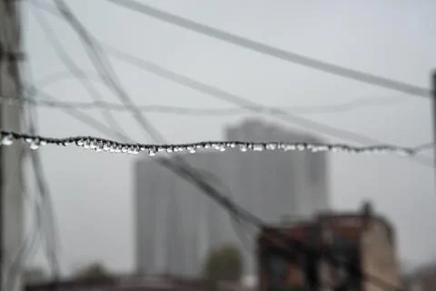 Clothesline cable full of small drops on a rainy day with a selective focus Stock Photos