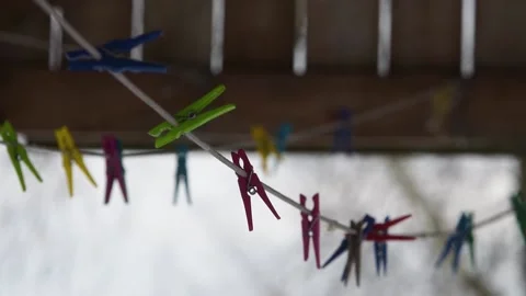A clothesline with pegs fluttering in the wind and in the background a plank Stock Footage 147856995