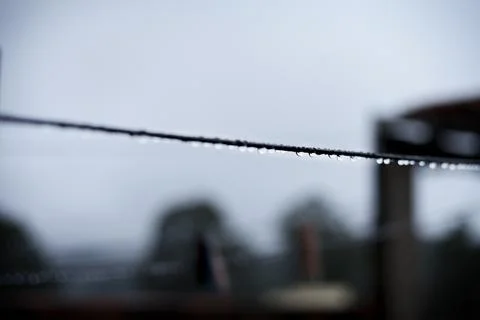 Clothesline with raindrops with dark sky in the background of a cloudy and ra Stock Photos