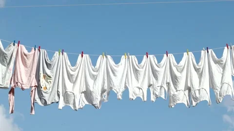 Clothesline, rope with clean white clothes during sunny summer day Stock Footage 163722424