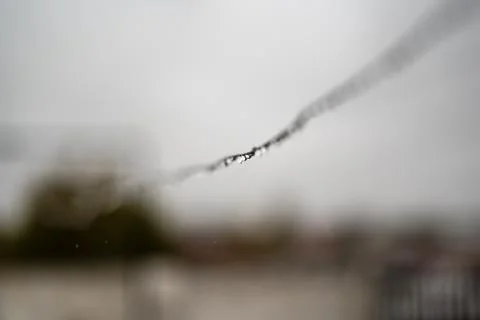 Clothesline wire full of small drops on a rainy day with a selective focus Stock Photos