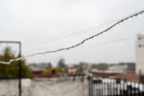 Clothesline wire full of small drops on a rainy day with a selective focus Stock Photos