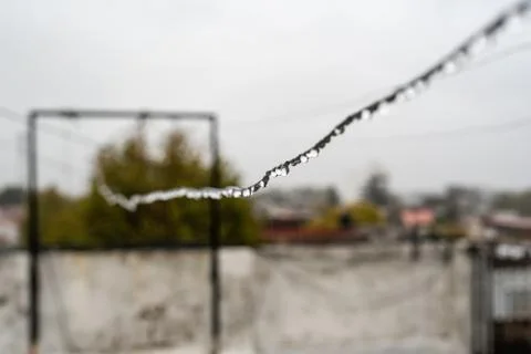 Clothesline wire full of small drops on a rainy day with a selective focus Stock Photos