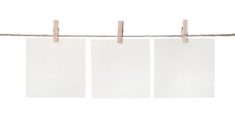 Clothespins with empty notepapers on string against white background. Space f Stock Photos
