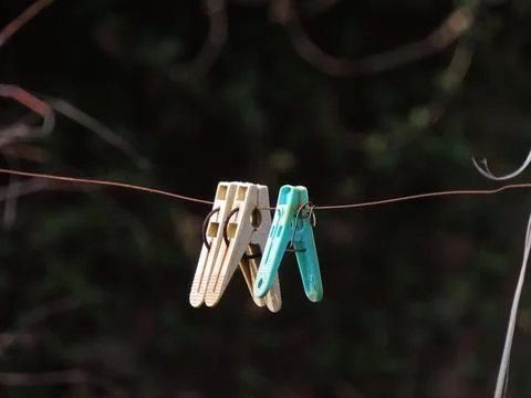 Clothespins hanging on a wire Stock Photos