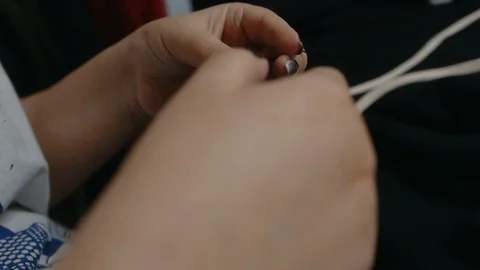 A clothing designer ties knots of thread on sewn clothes Stock Footage 129607034
