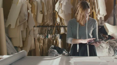 Clothing designer is working with a tablet in a workshop Stock Footage