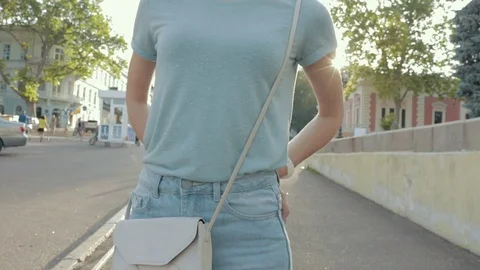 Clothing details: a young woman in jeans and a T-shirt Stock Footage