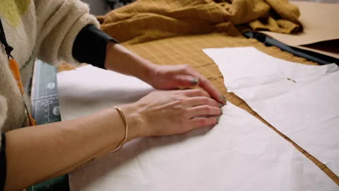 Clothing making pinning sewing pattern templates to fabric. wide shot Stock Footage 263524324