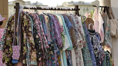 Clothing rack displaying colorful block print kaftans and boho apparel at a Stock Footage 344930260