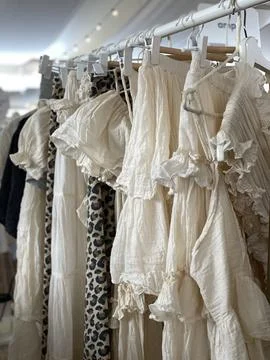 Clothing rack with a selection of flowy, patterned garments in light and so.. Foto stock
