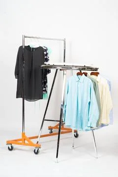 Clothing Racks with Assorted Garments in Studio on White Background Stock Photos