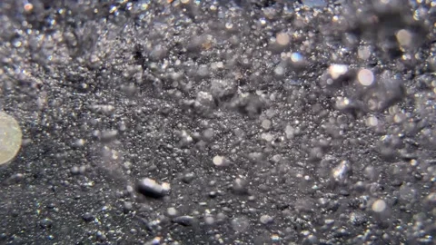 Cloud of air bubbles drifts underwater through seawater creating gentle movement Видео 342726278