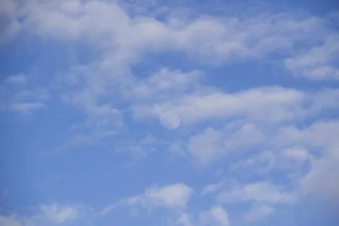 Cloud and the moon in the blue sky. A beautiful clouds against the blue sky b Stock Photos