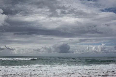 Cloud and waves on the beach Stock Photos