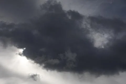 Cloud blocks sun. Grey day. Gray clouds in sky. Stock Photos