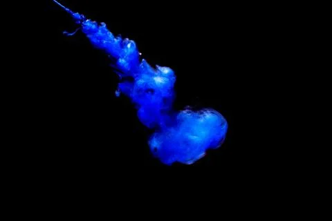 A cloud of blue paint released into clear water. Isolate on a black backgroun Foto stock