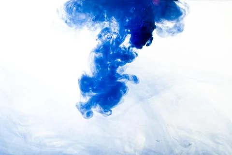 A cloud of blue paint released into clear water. Isolate on a white backgroun Stock Photos