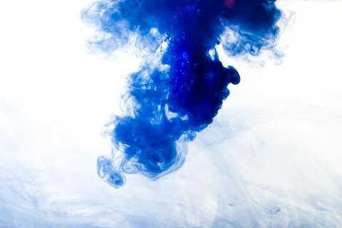 A cloud of blue paint released into clear water. Isolate on a white backgroun Stock Photos