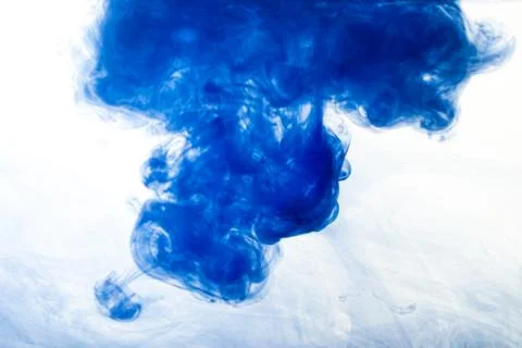 A cloud of blue paint released into clear water. Isolate on a white backgroun Stock Photos