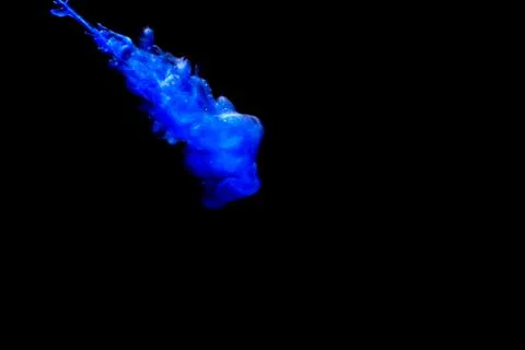 A cloud of blue paint released into clear water. Isolate on a black backgroun Stock Photos