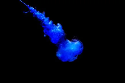 A cloud of blue paint released into clear water. Isolate on a black backgroun Foto stock