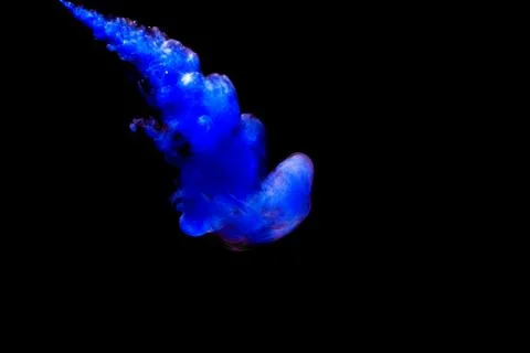 A cloud of blue paint released into clear water. Isolate on a black backgroun Foto stock