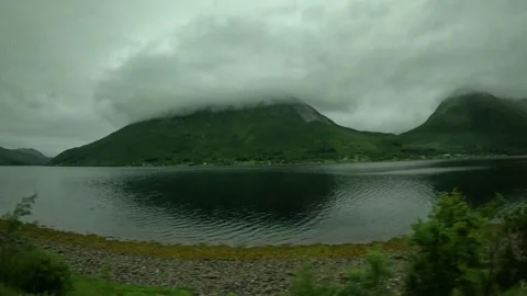 Cloud covered mountain peak over calm fjord driving view Norway Stock-Footage 341814600