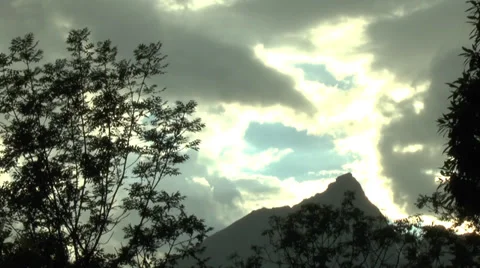 Cloud-Covered Sky with Sunlight Seeping Down above Mountains and Tree Branches 1 動画素材 32256118