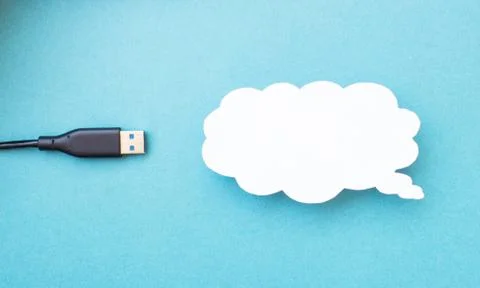 Cloud for data storage cut from paper on a blue background and cable usb, close Foto stock