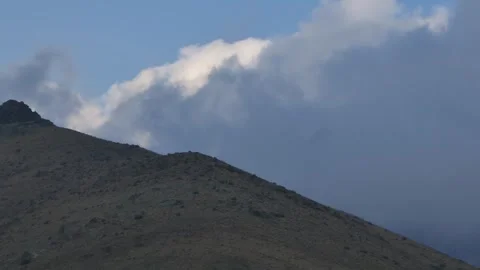 Cloud drifting above hillside with soft evening light Stock Footage 317821649