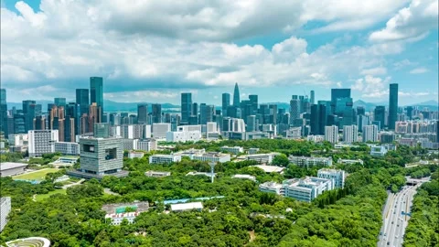 Cloud filled sky over a tree covered campus - Shenzhen Stock Footage 346614800