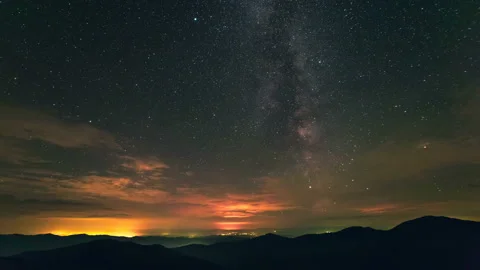 The cloud flow above mountains on the starry sky background. time lapse Video stock 95209867